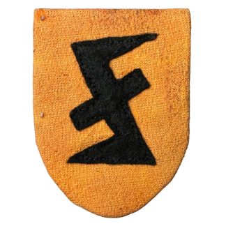 Embleem van de Vlaamse Zwarte Brigade: Een schildje met een gele achtergrond en zwarte Wolfsangel, Dit symbool vertegenwoordigde de Vlaamse collaboratie tijdens de Tweede Wereldoorlog.