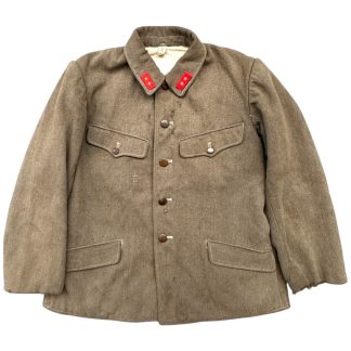 World War II Japanese Army Type 3 winter uniform jacket made of heavy brown wool, featuring a button-down front with dark brown buttons and four pockets with flaps. The jacket has a folded collar with red insignia patches adorned with gold stars, signifying rank or affiliation. The thick material and design are tailored for cold-weather conditions, showing signs of use and age.