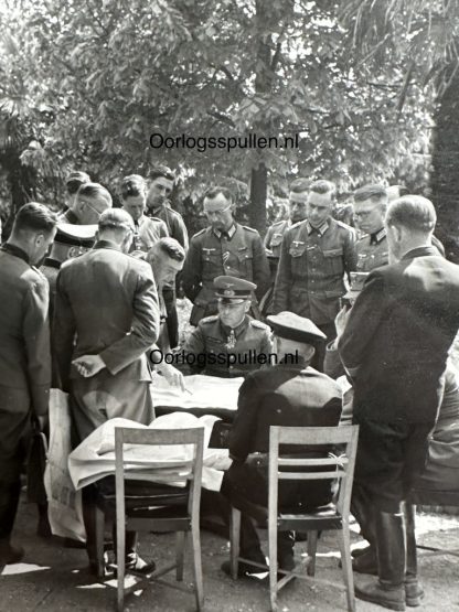 Erwin Rommel inspecting the battle plan at the Normandy coast in 1944. He is inspecting several maps with his officers.