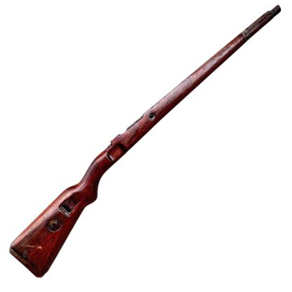 German WWII Mauser K98 wooden rifle stock, showcasing a rich reddish-brown wood finish with visible wear and aging, featuring the characteristic design for a bolt-action rifle. The stock includes a cutout for the bolt mechanism and a recess for the magazine well, highlighting its historical craftsmanship.