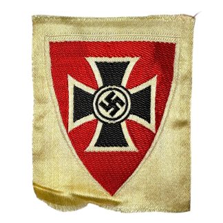 German Kyffhäuserbund emblem from World War II, featuring a black Iron Cross with a swastika in the center, set on a red shield with a cream-colored border, preserved in historical condition.