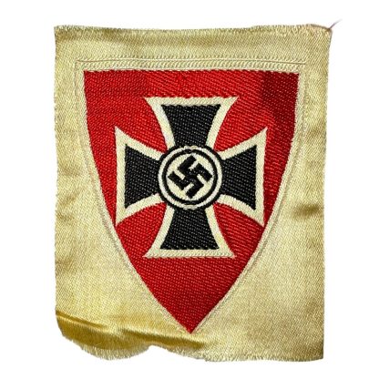 German Kyffhäuserbund emblem from World War II, featuring a black Iron Cross with a swastika in the center, set on a red shield with a cream-colored border, preserved in historical condition.