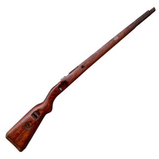 German WWII Mauser K98 wooden rifle stock, showcasing a rich reddish-brown finish, with visible wear and patina from age and use. The stock includes a cutout for the bolt handle and features slots for a sling, along with a detailed grain pattern typical of wartime production.