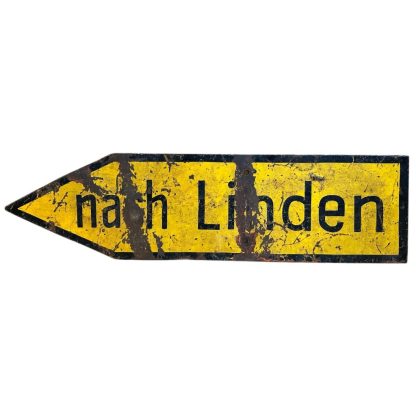 A weathered yellow metal German traffic sign from World War II with an arrow-shaped design, black border, and the text 'nach Linden' in black letters, showing clear signs of age and damage.