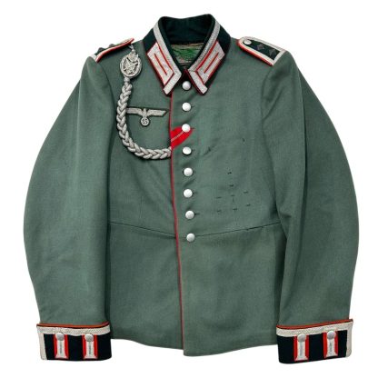 An original German Wehrmacht artillery Waffenrock uniform jacket from World War II, in green with red piping. The jacket features metal buttons, shoulder boards with red accents, a braided shoulder cord, an army eagle insignia, and traditional collar and cuff detailing with artillery insignias.