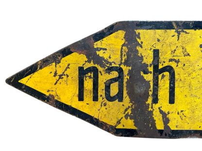 A weathered yellow metal German traffic sign from World War II with an arrow-shaped design, black border, and the text 'nach Linden' in black letters, showing clear signs of age and damage.