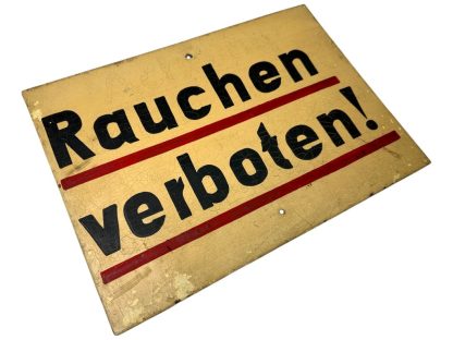 Metal German sign with the text 'Rauchen verboten!' from World War II, featuring a yellow background, black text with red underlining, and visible aging such as crackling and paint wear.