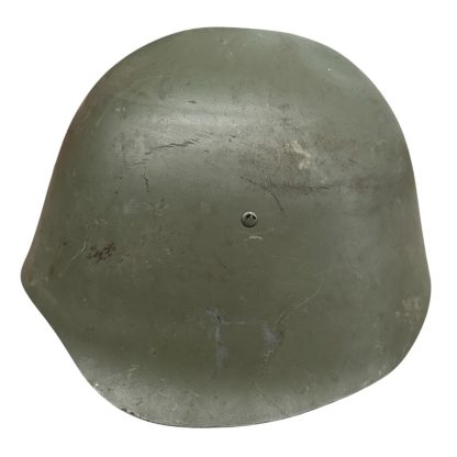 A WWII Danish M23/41 military helmet, featuring a rounded steel design with a green matte finish and a slightly flared brim. The helmet shows signs of wear, including scuffs and a small patch of exposed metal due to paint chipping. A single rivet is visible at the front for ventilation or securing the liner.