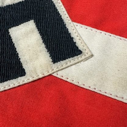 Original Hitler Youth armband from World War II, red with a white band and a black swastika in a diamond-shaped design, preserved in historical condition.