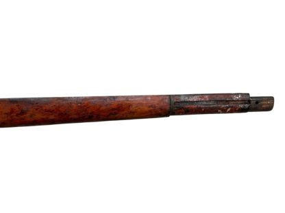 Image d'une crosse en bois allemande de fusil Mauser K98 de la Seconde Guerre mondiale, avec une finition brun foncé patinée et des découpes visibles pour fixer le mécanisme du fusil.