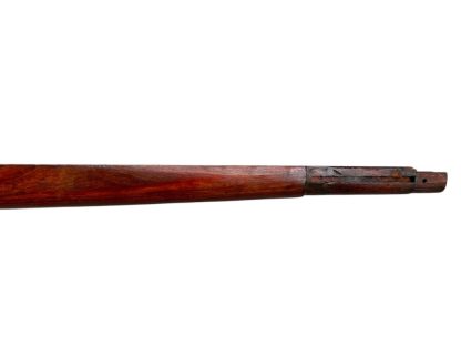 A vintage wooden rifle stock for a German WWII Mauser K98, showcasing a polished reddish-brown finish with visible wood grain texture. The design features a curved grip and cutouts for mounting hardware. The stock appears well-preserved with signs of age and use, such as minor scuffs and wear, adding to its historical authenticity.