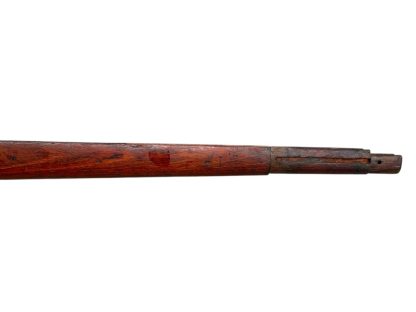 German WWII Mauser K98 wooden rifle stock, showcasing a rich reddish-brown finish, with visible wear and patina from age and use. The stock includes a cutout for the bolt handle and features slots for a sling, along with a detailed grain pattern typical of wartime production.