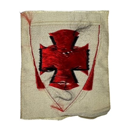 German Kyffhäuserbund emblem from World War II, featuring a black Iron Cross with a swastika in the center, set on a red shield with a cream-colored border, preserved in historical condition.