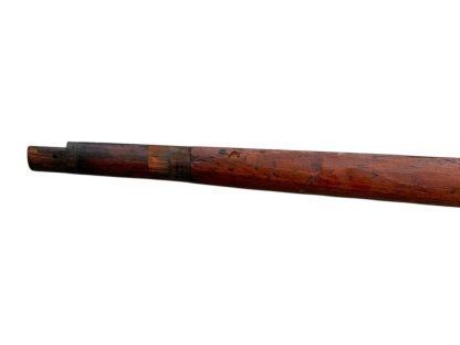 German WWII Mauser K98 wooden rifle stock, showcasing a rich reddish-brown finish, with visible wear and patina from age and use. The stock includes a cutout for the bolt handle and features slots for a sling, along with a detailed grain pattern typical of wartime production.