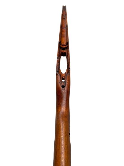 A vintage wooden rifle stock for a German WWII Mauser K98, showcasing a polished reddish-brown finish with visible wood grain texture. The design features a curved grip and cutouts for mounting hardware. The stock appears well-preserved with signs of age and use, such as minor scuffs and wear, adding to its historical authenticity.