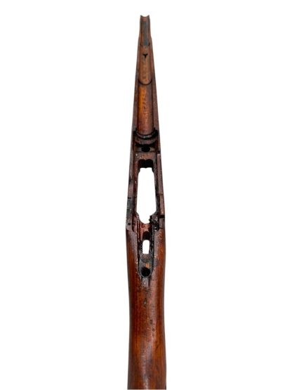 A vintage wooden rifle stock for a German WWII Mauser K98, showcasing a polished reddish-brown finish with visible wood grain texture. The design features a curved grip and cutouts for mounting hardware. The stock appears well-preserved with signs of age and use, such as minor scuffs and wear, adding to its historical authenticity.