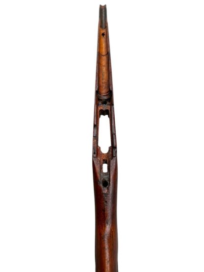 German WWII Mauser K98 wooden rifle stock, showcasing a rich reddish-brown finish, with visible wear and patina from age and use. The stock includes a cutout for the bolt handle and features slots for a sling, along with a detailed grain pattern typical of wartime production.