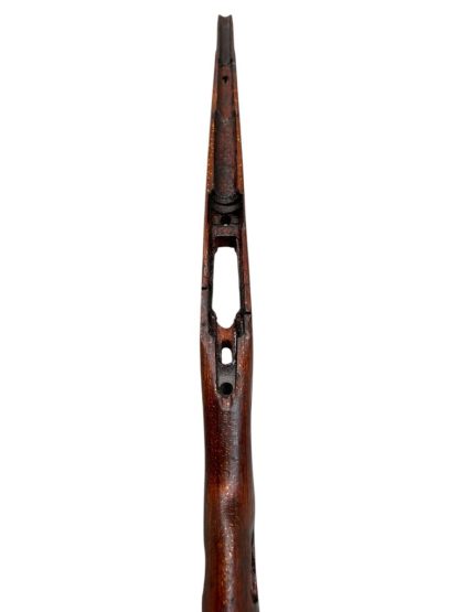 German WWII Mauser K98 wooden rifle stock, showcasing a rich reddish-brown finish, with visible wear and patina from age and use. The stock includes a cutout for the bolt handle and features slots for a sling, along with a detailed grain pattern typical of wartime production.