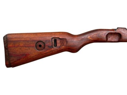 Bild eines deutschen hölzernen Mauser K98 Gewehrschafts aus dem Zweiten Weltkrieg, mit einer tiefbraunen, verwitterten Oberfläche und sichtbaren Aussparungen zur Befestigung des Gewehrmechanismus.