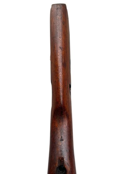 German WWII Mauser K98 wooden rifle stock, showcasing a rich reddish-brown wood finish with visible wear and aging, featuring the characteristic design for a bolt-action rifle. The stock includes a cutout for the bolt mechanism and a recess for the magazine well, highlighting its historical craftsmanship.