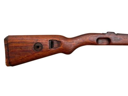 Image of a German wooden Mauser K98 rifle stock from World War II, featuring a deep brown, weathered finish and visible cutouts for attaching the rifle mechanism.