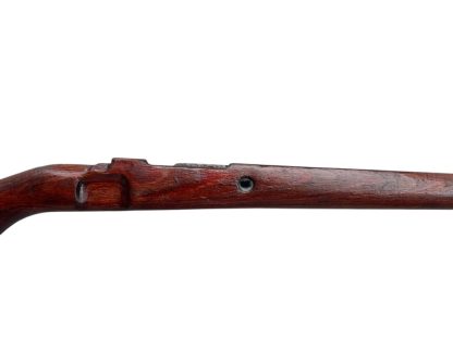 German WWII Mauser K98 wooden rifle stock, showcasing a rich reddish-brown wood finish with visible wear and aging, featuring the characteristic design for a bolt-action rifle. The stock includes a cutout for the bolt mechanism and a recess for the magazine well, highlighting its historical craftsmanship.