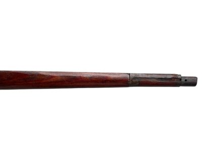 German WWII Mauser K98 wooden rifle stock, showcasing a rich reddish-brown wood finish with visible wear and aging, featuring the characteristic design for a bolt-action rifle. The stock includes a cutout for the bolt mechanism and a recess for the magazine well, highlighting its historical craftsmanship.