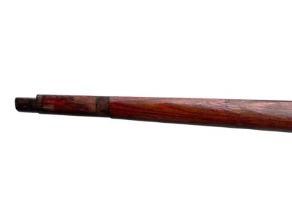 German WWII Mauser K98 wooden rifle stock, showcasing a rich reddish-brown wood finish with visible wear and aging, featuring the characteristic design for a bolt-action rifle. The stock includes a cutout for the bolt mechanism and a recess for the magazine well, highlighting its historical craftsmanship.