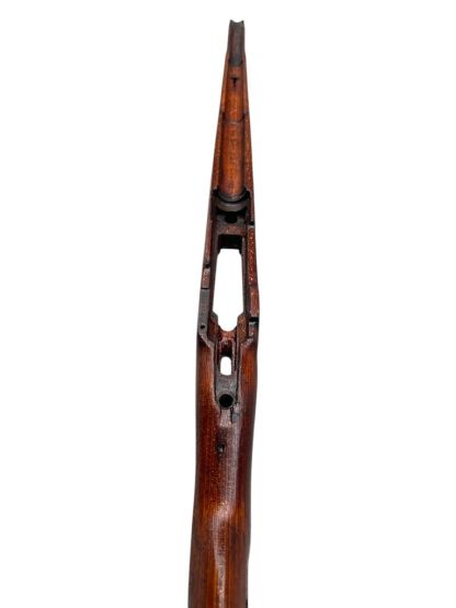 German WWII Mauser K98 wooden rifle stock, showcasing a rich reddish-brown wood finish with visible wear and aging, featuring the characteristic design for a bolt-action rifle. The stock includes a cutout for the bolt mechanism and a recess for the magazine well, highlighting its historical craftsmanship.