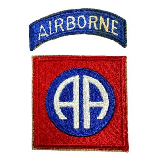 A World War II-era U.S. 82nd Airborne Division patch with a white back. The patch consists of a curved blue tab with 'AIRBORNE' embroidered in white thread, and a square red patch featuring a blue circle with a white 'AA' insignia in the center, representing the 'All American' nickname of the division.