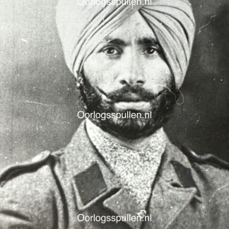 Black and white historical portrait of a Sikh soldier from the Freies Indien Legion, wearing a turban and a military uniform with epaulettes. His thick beard and mustache are well-groomed, and he has a serious expression. The uniform appears to be from the World War II era.