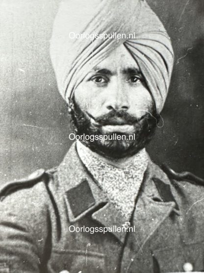 Black and white historical portrait of a Sikh soldier from the Freies Indien Legion, wearing a turban and a military uniform with epaulettes. His thick beard and mustache are well-groomed, and he has a serious expression. The uniform appears to be from the World War II era.