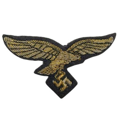 WWII German Luftwaffe General's breast eagle insignia, featuring a gold-embroidered eagle with outstretched wings clutching a swastika, set on a blue fabric background.