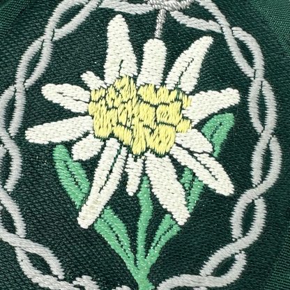 Original WWII German Wehrmacht Gebirgsjäger (Mountain Troops) arm insignia featuring an embroidered Edelweiss flower surrounded by a decorative border, symbolizing the elite mountain infantry.