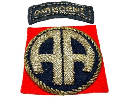 A World War II-era U.S. 82nd Airborne Division bullion patch, British-made. The patch consists of a curved black tab with 'AIRBORNE' embroidered in gold bullion thread and a square red patch featuring a gold bullion 'AA' insignia on a dark blue background, surrounded by gold braiding.