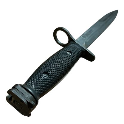 This is an image of a bayonet, specifically the M7 bayonet. It was originally designed to be mounted on the M16 rifle and is a product of the U.S. military's development. The M7 features a sharp blade with a fuller and is designed for utility and combat purposes. Its handle typically has a textured grip, and the design includes a guard and attachment mechanism for the rifle.