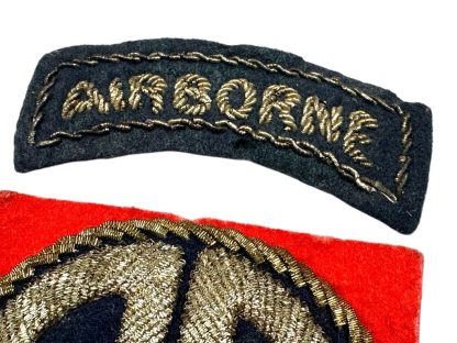 A World War II-era U.S. 82nd Airborne Division bullion patch, British-made. The patch consists of a curved black tab with 'AIRBORNE' embroidered in gold bullion thread and a square red patch featuring a gold bullion 'AA' insignia on a dark blue background, surrounded by gold braiding.