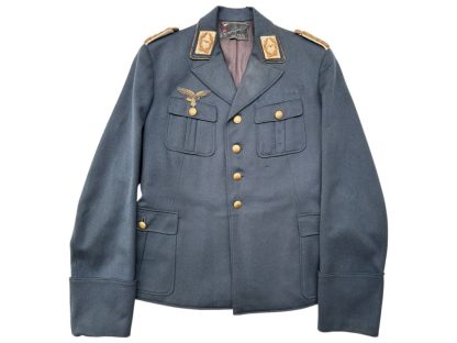 WWII German Luftwaffe General's tunic in blue-gray fabric, featuring gold buttons, gold-embroidered shoulder boards, a gold-braided breast eagle insignia on the right chest, and four front pockets with flaps.