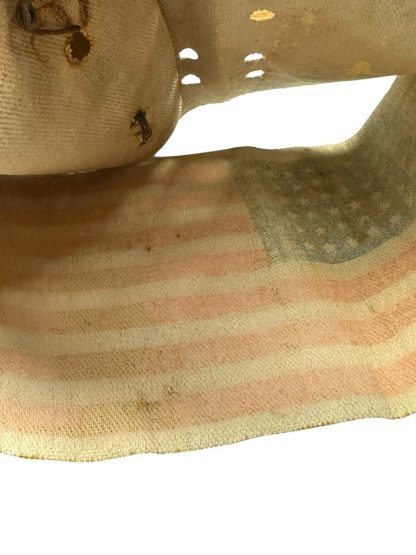 A worn and aged WWII US Airborne invasion armband featuring a faded American flag design with 48 stars, printed on a yellowed fabric background with visible cracks and creases.