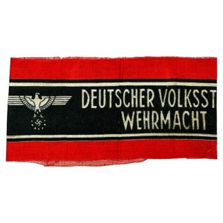 A WWII-era German Volkssturm armband featuring a red fabric background with a black central band, bordered by white stripes. The text 'DEUTSCHER VOLKSSTURM WEHRMACHT' is printed in white, alongside an eagle and swastika emblem. The fabric appears worn with frayed edges.