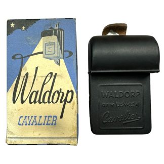 Vintage Waldorp Cavalier zaklamp uit de Luchtbeschermingsdienst (LBD) van Nederland, compleet met originele verpakking. De zwarte zaklamp heeft een leren schakelaardeksel en reliëftekst, terwijl de doos een art-deco ontwerp toont met een zoeklichtillustratie en Waldorp-logo.