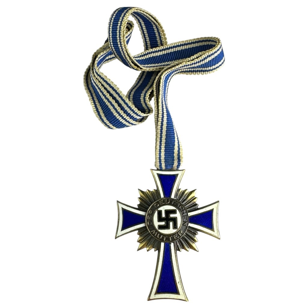 A German Mother's Cross in Bronze (Ehrenkreuz der Deutschen Mutter), awarded during the Nazi era. The medal is a bronze-outlined blue enameled cross with a sunburst pattern behind it, featuring a swastika at the center and the inscription "DER DEUTSCHEN MUTTER." It is attached to a blue and white striped ribbon.