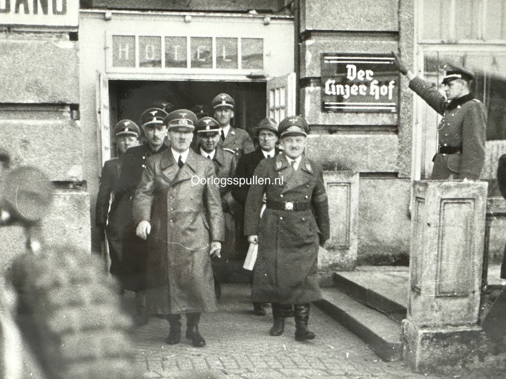 Rare WWII photo of Adolf Hitler exiting the ‘Der Linzer Hof’ hotel in Linz with SS officers—valuable for collectors of Third Reich memorabilia, showing original uniforms, architecture, and historical context.
