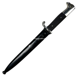 Original WWII German K98 dress bayonet by WKC, highly collectible example featuring a sleek black-painted scabbard and nickel-plated fittings. Designed for parade or dress use rather than combat, this piece showcases the quality craftsmanship of Weyersberg, Kirschbaum & Cie. A desirable item for militaria collectors, especially those focused on Third Reich edged weapons or K98 rifle accessories.