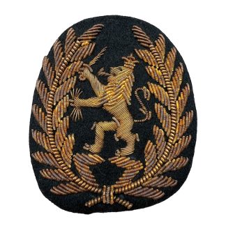 Origineel Nederlands KNIL officiers petembleem 1945-1949, Koninklijk Nederlands-Indisch Leger insigne met geborduurde gouden leeuw en lauwerkrans, zeldzaam militair verzamelobject uit Nederlands-Indië.