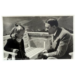 Historische Schwarz-Weiß-Postkarte, Adolf Hitler im Gespräch mit einem kleinen Mädchen auf einer Terrasse am Obersalzberg. Im Hintergrund die Berglandschaft der bayerischen Alpen. Zeitdokument aus der NS-Zeit.