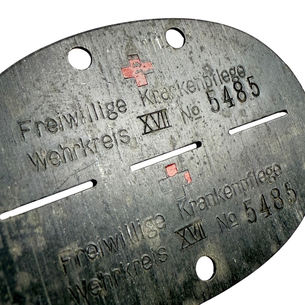 Original WWII German Red Cross dog tag Erkennungsmarke Freiwillige Krankenpflege Wehrkreis XVII No. 5485 with red enamel cross – rare DRK medical ID disc.