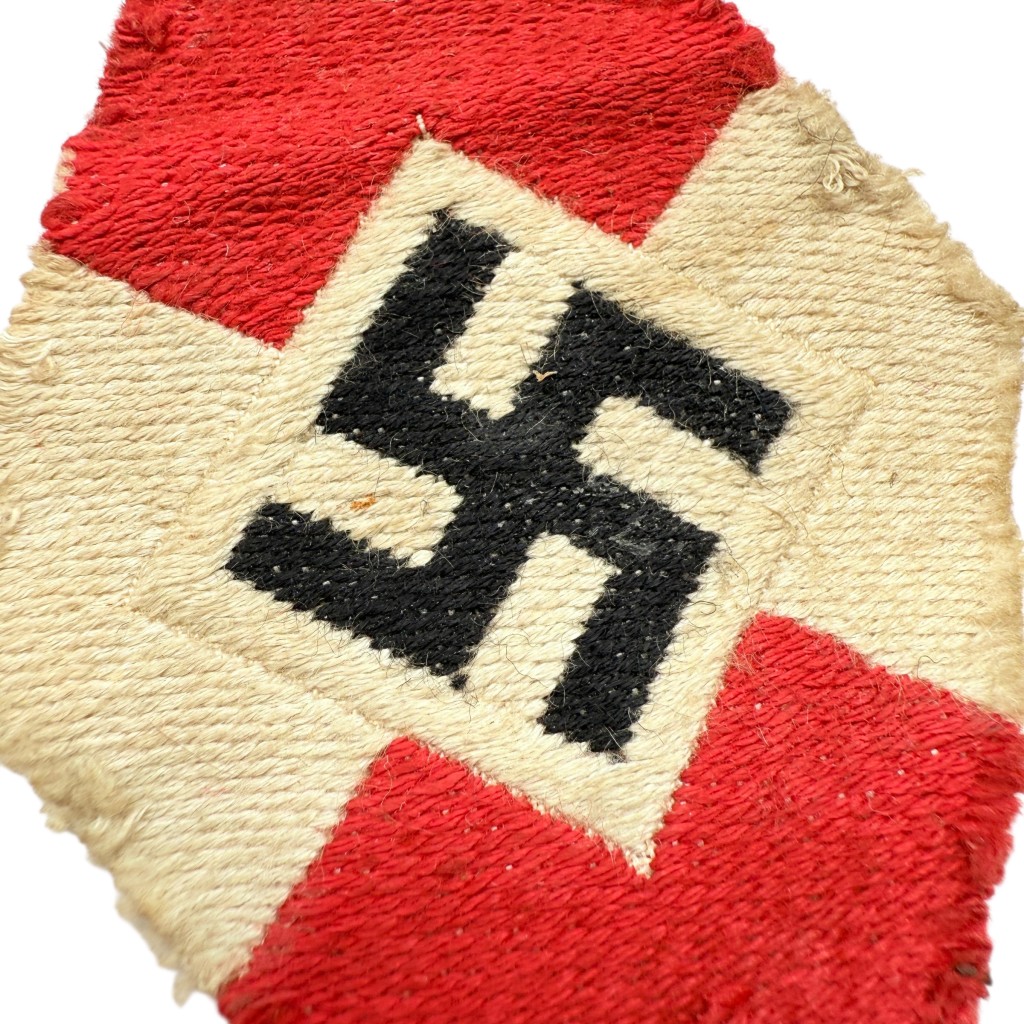 Close-up of WWII German Hitlerjugend (HJ) / Bund Deutscher Mädel (BDM) sleeve diamond insignia, showing woven textile details and swastika design.