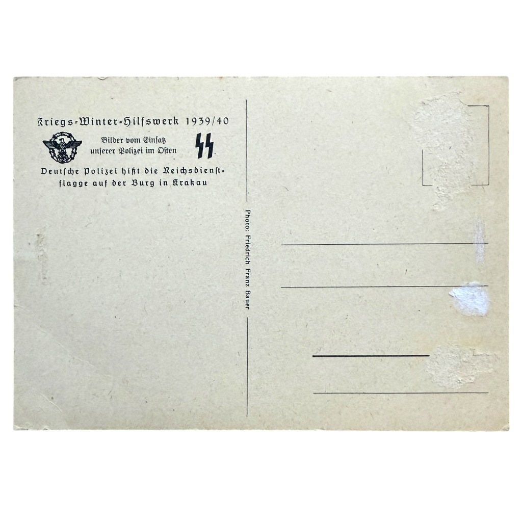 Oryginalna pocztówka z II wojny światowej – niemiecka SS-Polizei w Krakowie, Polska. Rzadkie historyczne zdjęcie żołnierzy wznoszących flagę, autentyczny kolekcjonerski przedmiot militaria z okresu Trzeciej Rzeszy, unikalna pamiątka dla pasjonatów historii wojskowej.