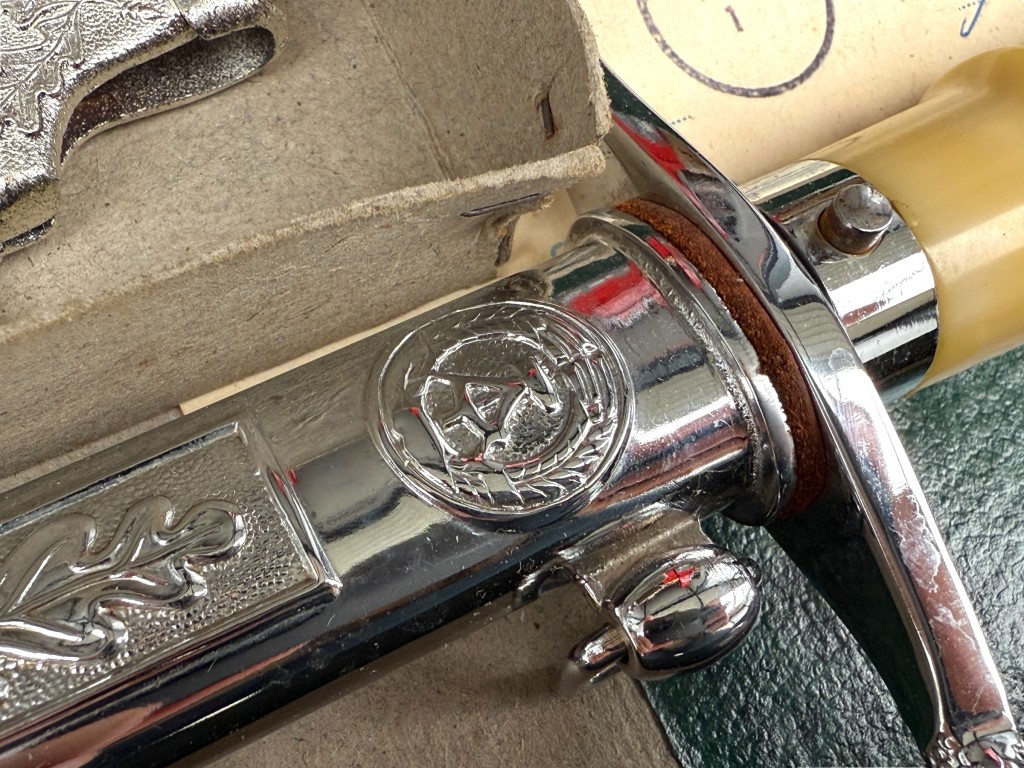 NVA emblem and oak leaf decoration on East German officer dagger scabbard – DDR National People’s Army collectible.